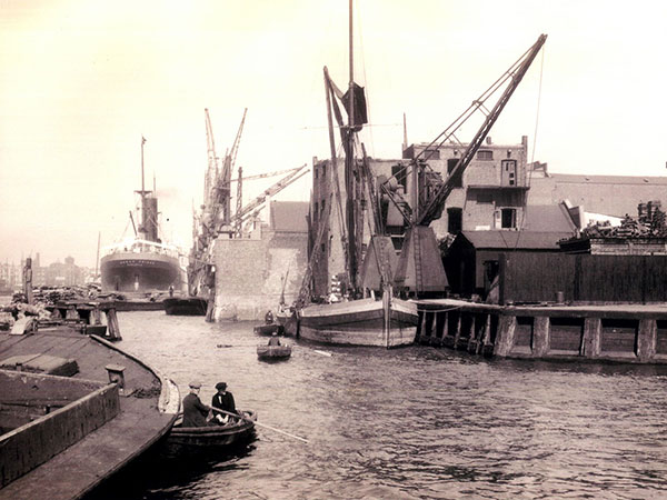 Ship docked at riverside wharf in 1930s